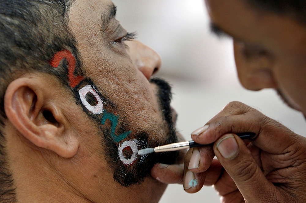 Thế giới chuẩn bị đón năm mới 2020 - Một người đàn ông sơn số 2020 lên râu tại tiệm cắt tóc ở thành phố Ahmedabad, Ấn Độ.